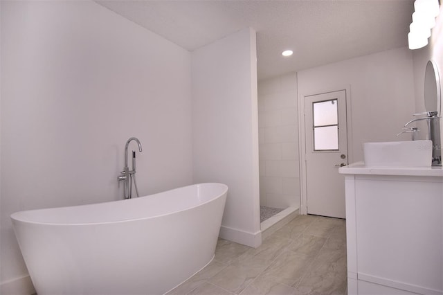 bathroom featuring vanity, a textured ceiling, and plus walk in shower