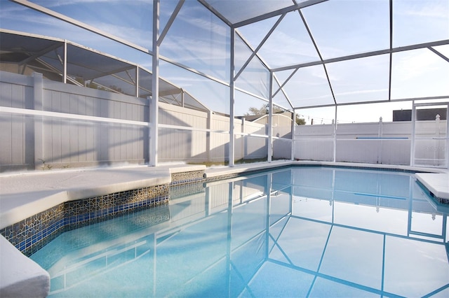 view of swimming pool featuring glass enclosure