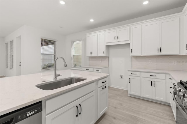 kitchen with stainless steel appliances, white cabinetry, and sink