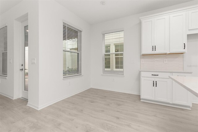 unfurnished dining area featuring light wood-type flooring