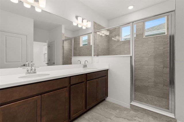 bathroom featuring a wealth of natural light, vanity, and walk in shower