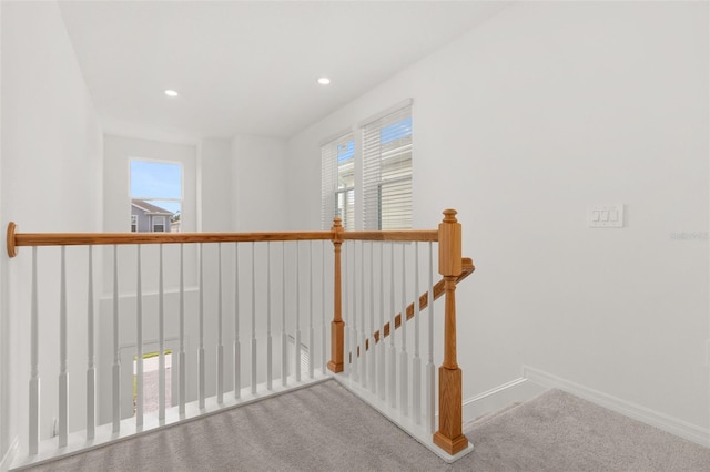 hallway with carpet floors and a healthy amount of sunlight