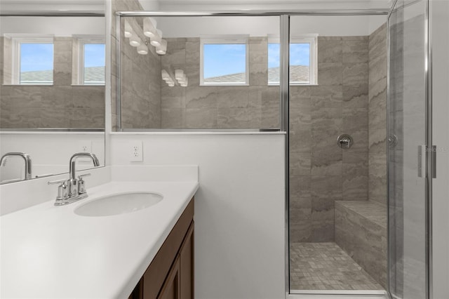 bathroom featuring an enclosed shower, vanity, and a wealth of natural light