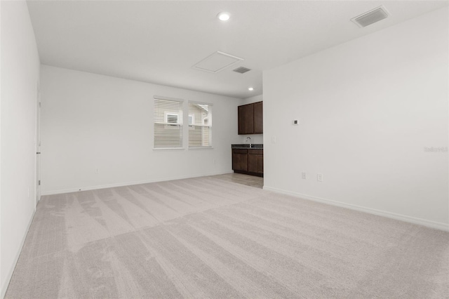 unfurnished living room with light colored carpet