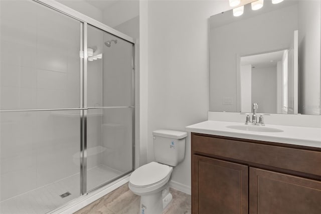 bathroom with vanity, toilet, and a shower with shower door