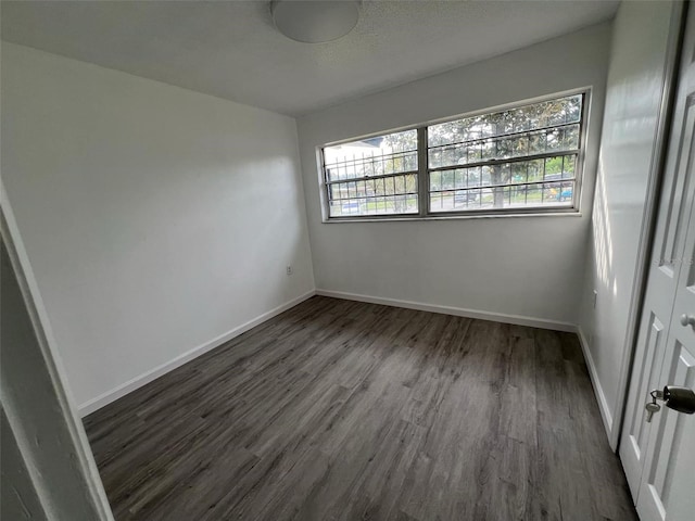 spare room with a healthy amount of sunlight and dark hardwood / wood-style flooring