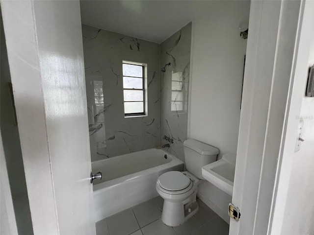 bathroom with toilet, tiled shower / bath combo, and tile patterned flooring