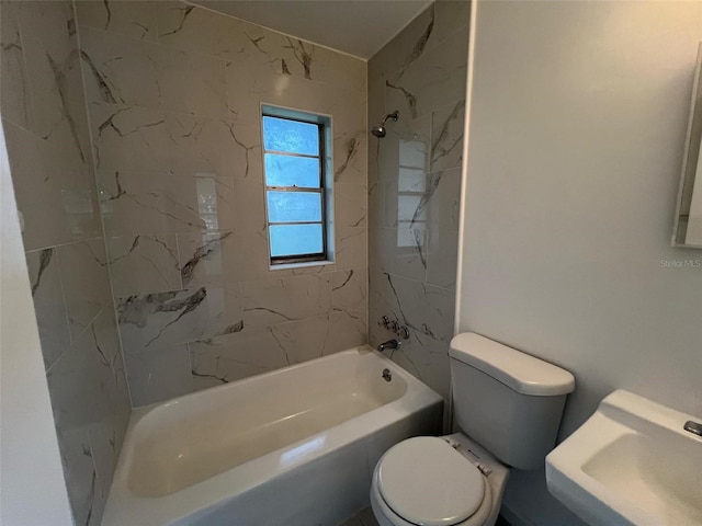 full bathroom with toilet, tiled shower / bath combo, and sink