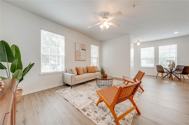 living room featuring ceiling fan and light hardwood / wood-style floors