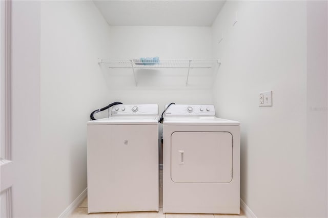 laundry room featuring washing machine and clothes dryer and light tile patterned floors