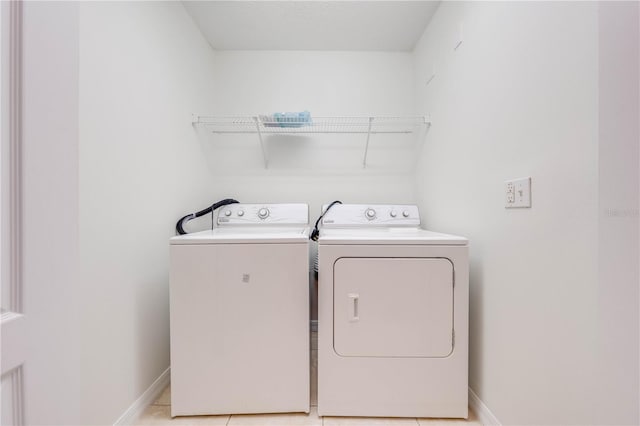 laundry area with baseboards, laundry area, and washer and clothes dryer