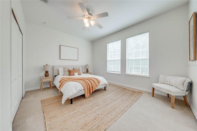 carpeted bedroom featuring a closet and ceiling fan