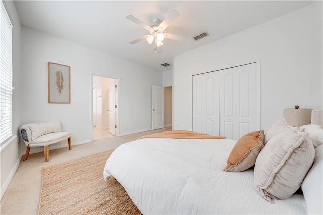 bedroom featuring baseboards, visible vents, light carpet, and a closet