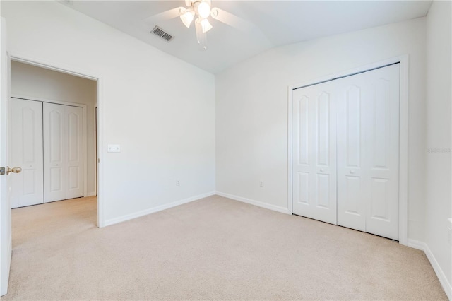 unfurnished bedroom featuring lofted ceiling, carpet flooring, baseboards, and visible vents