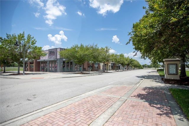 view of street featuring curbs, sidewalks, and street lighting