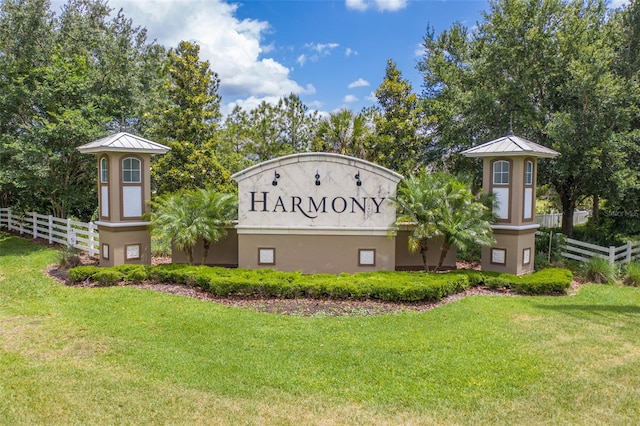 community sign featuring a lawn and fence