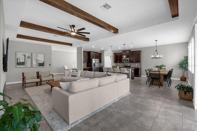 living room featuring beamed ceiling, light tile patterned floors, and ceiling fan with notable chandelier