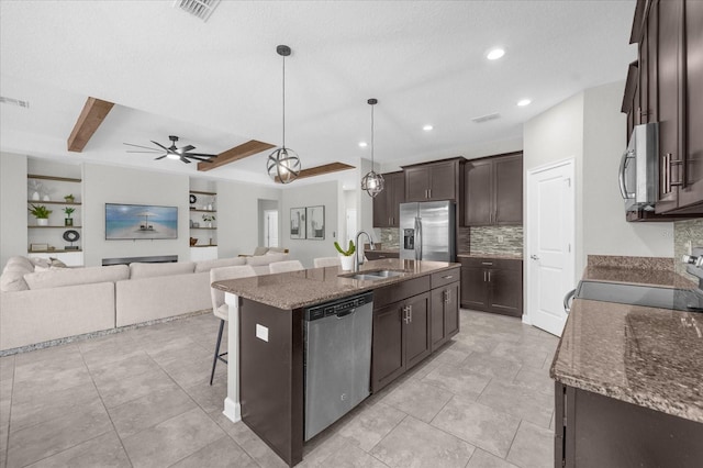 kitchen featuring sink, an island with sink, a kitchen breakfast bar, stainless steel appliances, and pendant lighting