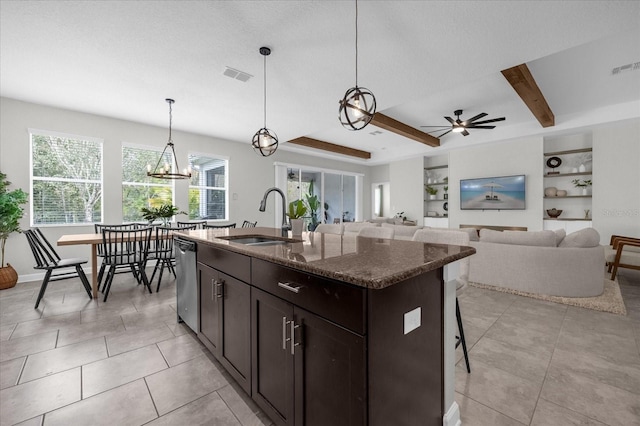 kitchen with pendant lighting, sink, plenty of natural light, and a kitchen island with sink