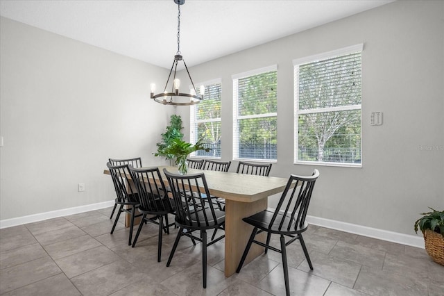 tiled dining room with a notable chandelier and plenty of natural light