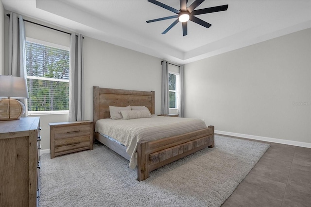 bedroom with a tray ceiling and ceiling fan