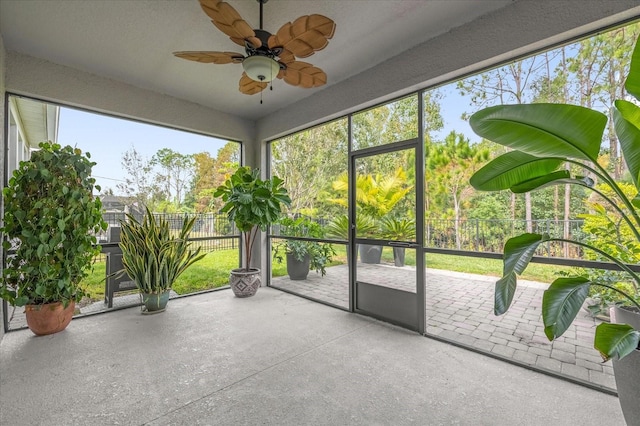 unfurnished sunroom with ceiling fan