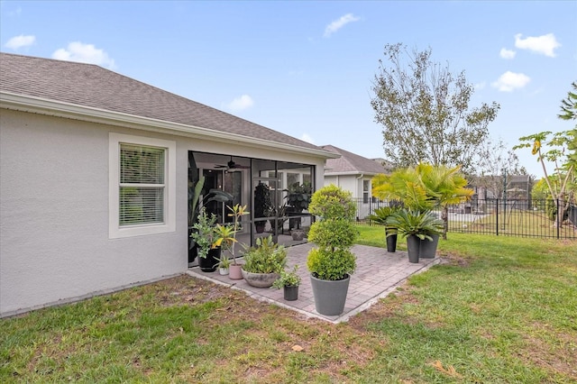 view of yard featuring a patio area, a sunroom, and ceiling fan