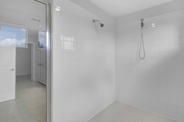 bathroom featuring tiled shower and tile patterned floors