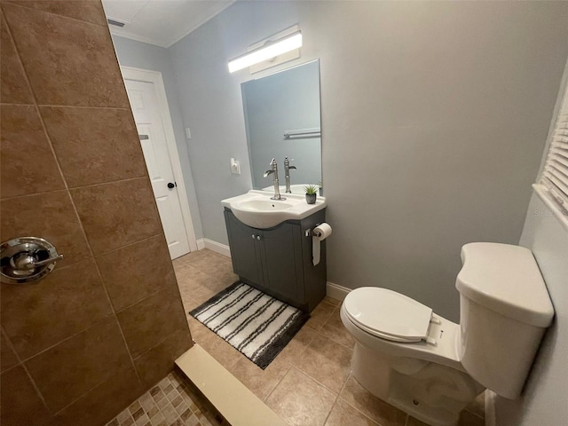 bathroom with tile patterned flooring, crown molding, vanity, toilet, and baseboards