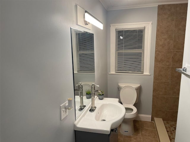 bathroom featuring toilet, tiled shower, vanity, crown molding, and tile patterned floors