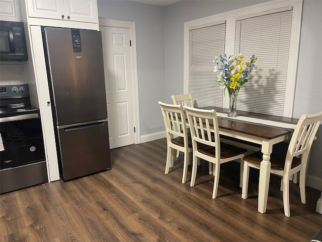 dining area featuring baseboards and dark wood-type flooring