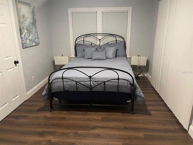 bedroom with dark wood-type flooring