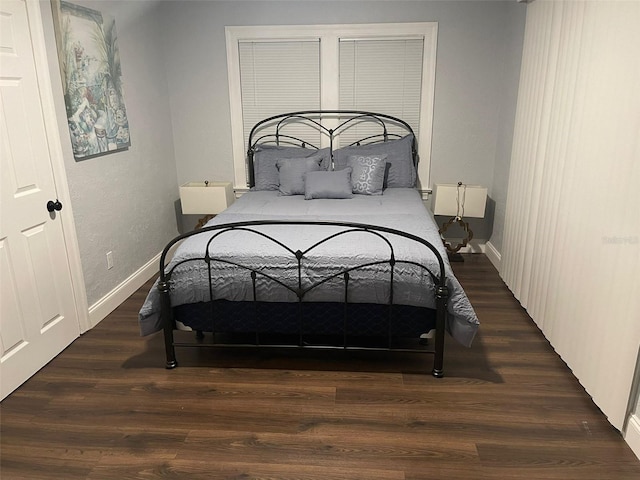 bedroom with baseboards and wood finished floors