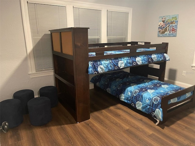 bedroom with baseboards and wood finished floors