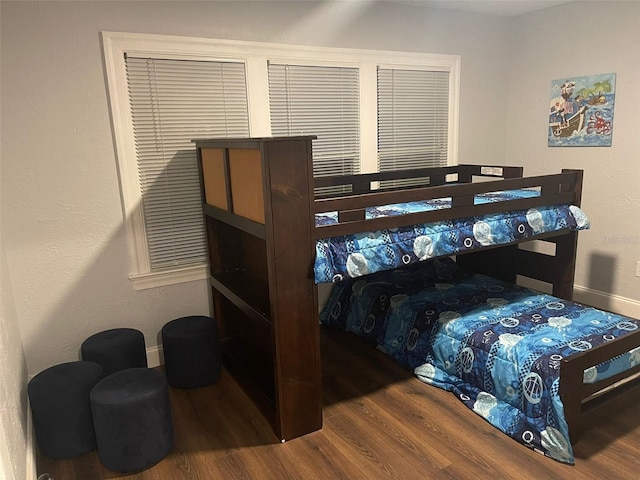 bedroom with baseboards and wood finished floors