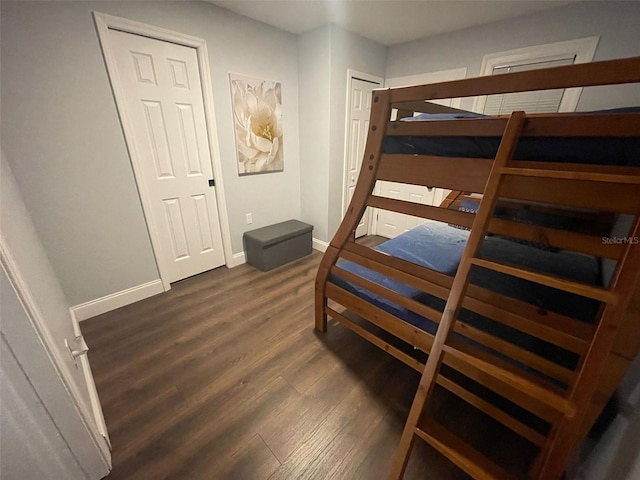 bedroom with baseboards and dark wood-type flooring