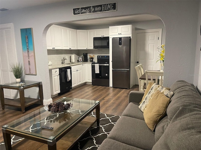 living room featuring sink and dark hardwood / wood-style floors