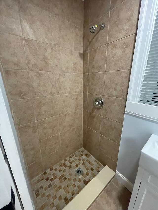 bathroom with vanity and tiled shower