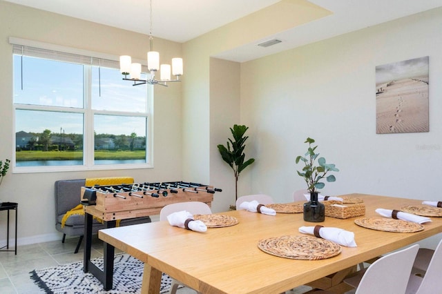 tiled dining room with a water view and a chandelier