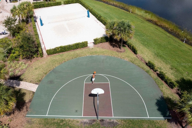 view of sport court with a yard and a water view