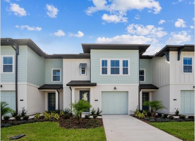 townhome / multi-family property featuring concrete driveway, an attached garage, and stucco siding