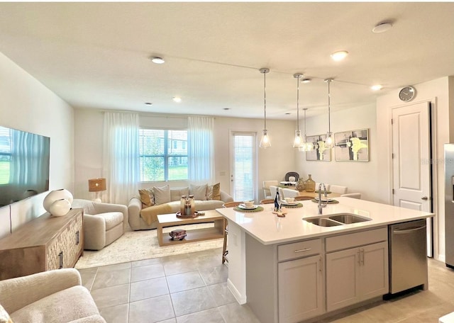 kitchen featuring open floor plan, a sink, dishwasher, light countertops, and light tile patterned floors