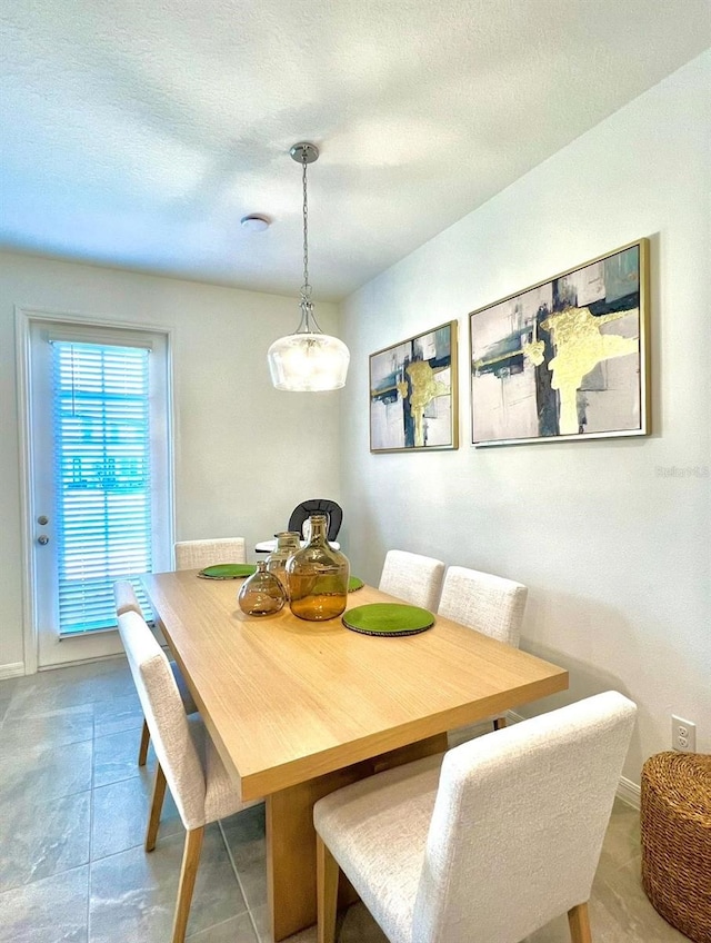 dining area featuring baseboards and a textured ceiling