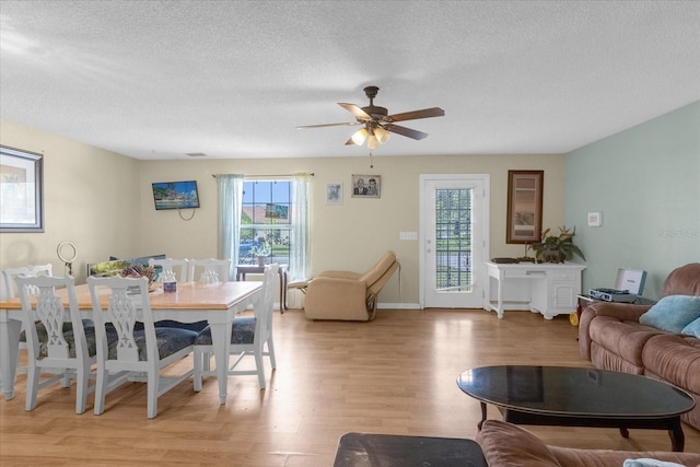 interior space with light hardwood / wood-style flooring, a textured ceiling, a healthy amount of sunlight, and ceiling fan