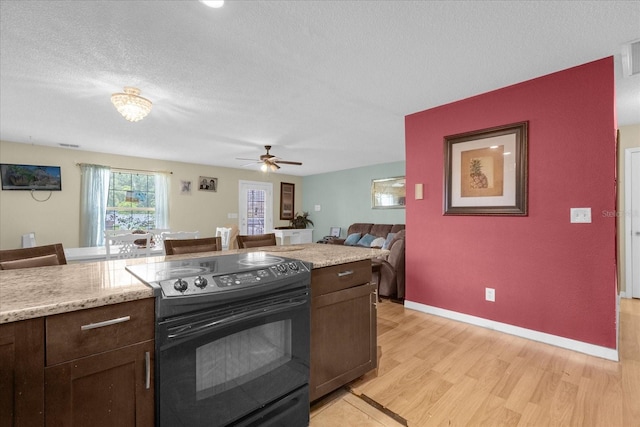 kitchen featuring black electric range oven, dark brown cabinets, ceiling fan, a textured ceiling, and light wood-type flooring