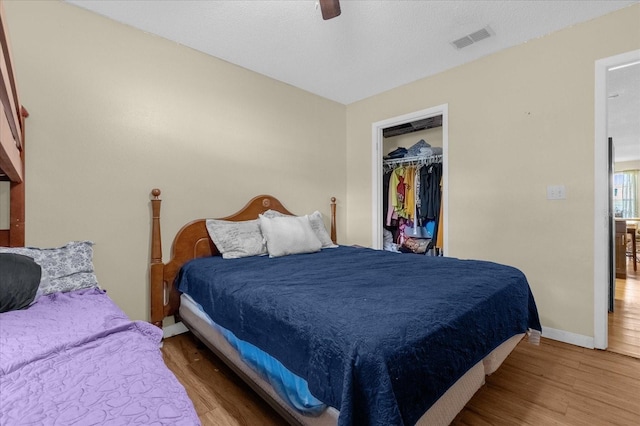 bedroom featuring a closet, a textured ceiling, wood-type flooring, and ceiling fan