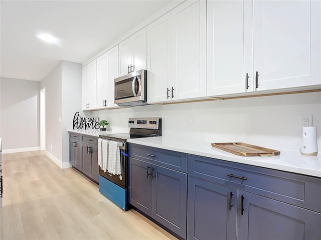 kitchen featuring white cabinetry, appliances with stainless steel finishes, and light wood-type flooring