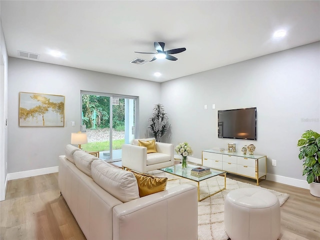 living room with light hardwood / wood-style flooring and ceiling fan