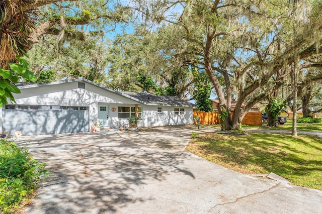 ranch-style house with a garage and a front lawn