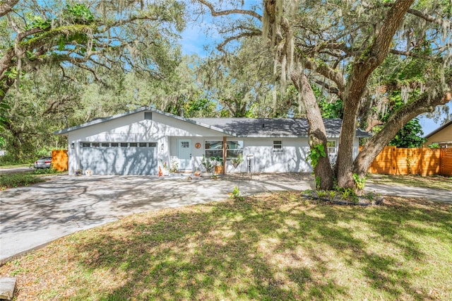 ranch-style home featuring a garage and a front lawn